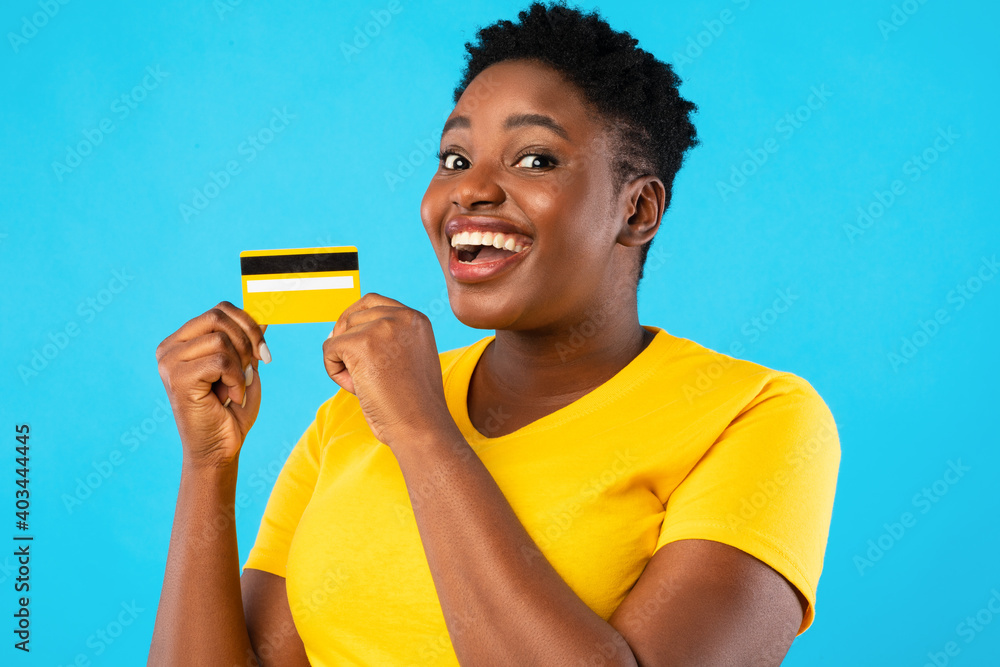 Excited African Woman Showing Credit Card Posing On Blue Background Excited African Woman Showing Credit Card Posing On Blue Background