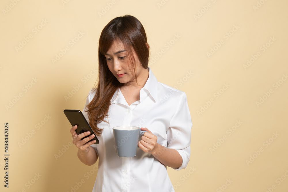 Young Asian woman with mobile phone and coffee cup. Young Asian woman with mobile phone and coffee cup.