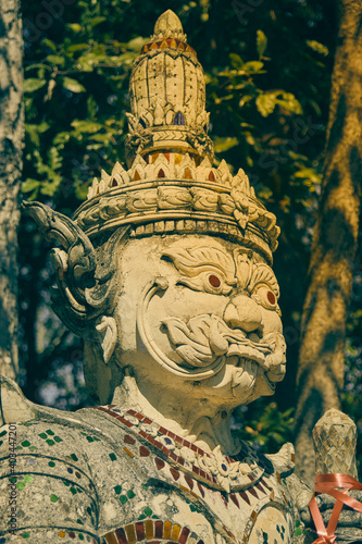Phayao, Thailand - Nov 22, 2020: Portrait Headshot White Titan or Giant in Color Mirror Suit and Green Forest Background in Wat Analayo Thai Temple in Vintage Tone