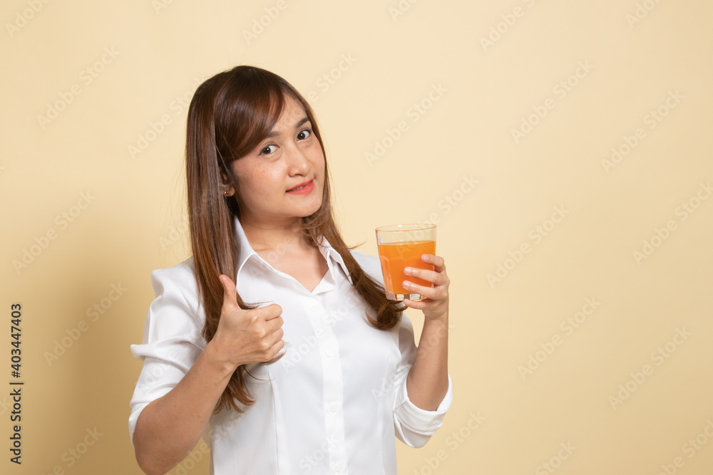 Young Asian woman thumbs up drink orange juice. Young Asian woman thumbs up drink orange juice.