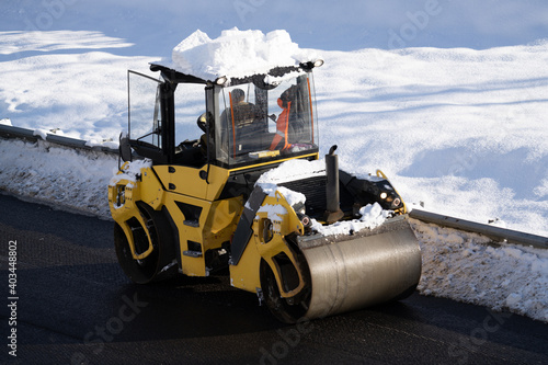 Winter repair work on the mountains. Heavy cars are laying asphalt