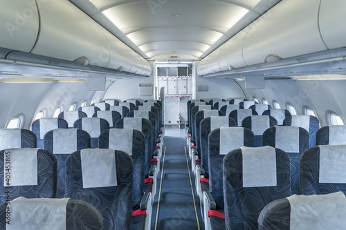 Airplane cabin and aisle with empty seats in economy class