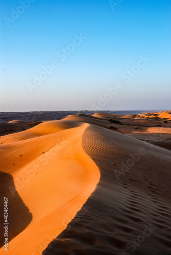 Dunes of the Arabian desert in Oman take on the colors of sunlight and wind, Wahiba Sands photo