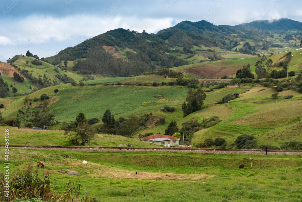 Country landscape in Boyaca, Colombia with mountains house and train track