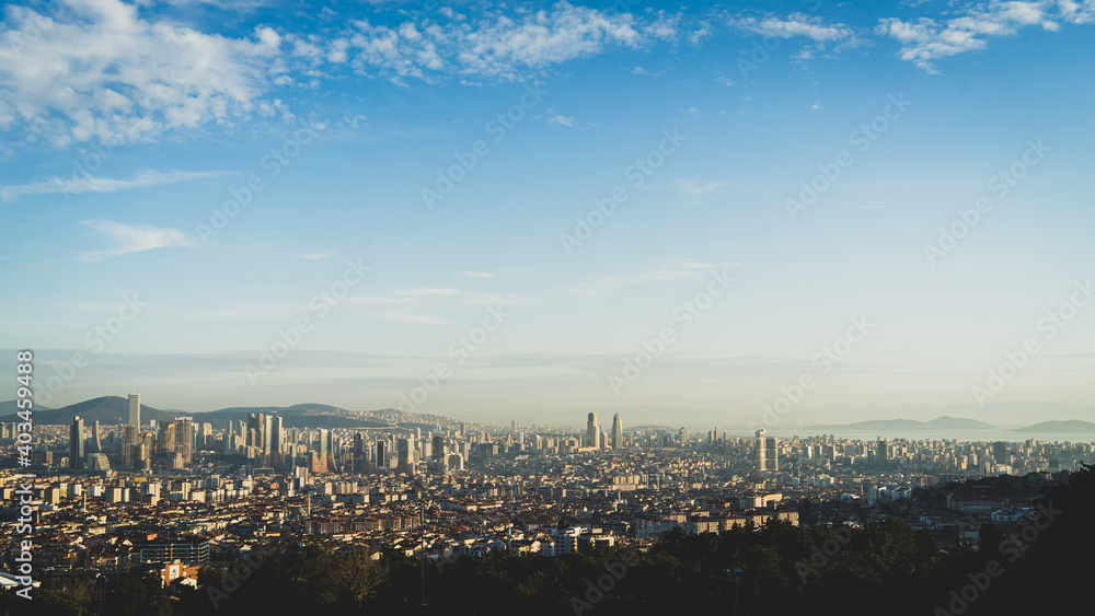 Panorama d'Istanbul sur une étendue d'immeubles et de gratte-ciels, des collines à l'horizon et la mer.