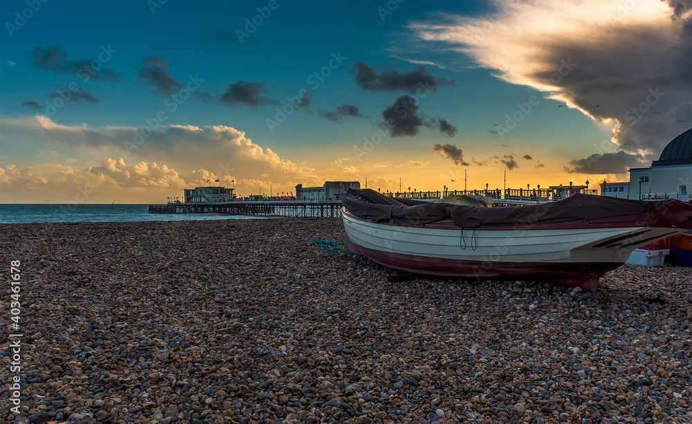 Naklejka premium A view across the beach out to sea at Worthing, Sussex, UK at sunset