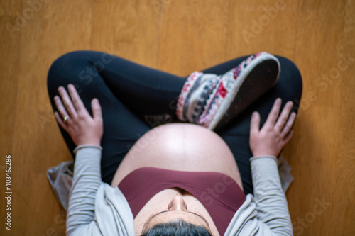 Overhead shot of a Pregnant woman sitting in lotus position or doing yoga  with copy space. Selective focus on face