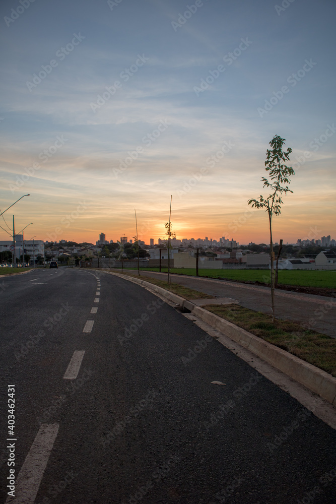 photo of road leading to town at the end of the day watching the sunset