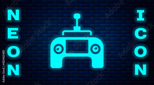 Glowing neon Drone radio remote control transmitter icon isolated on brick wall background. Vector.