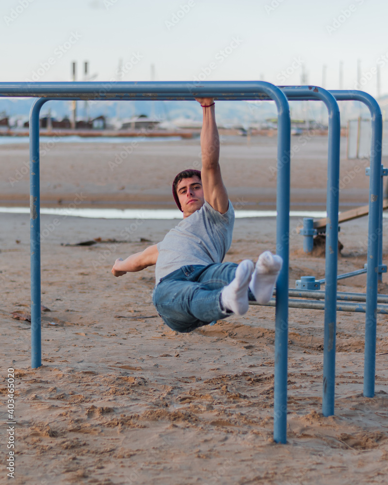 Calisthenics on the parallel bars in front of the beach. One arm front