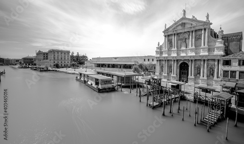 Immagine in bianco e nero della stazione ferroviaria di Venezia vicino alla Chiesa di Santa Maria di Nazareth e un molo da cui partono i traghetti 