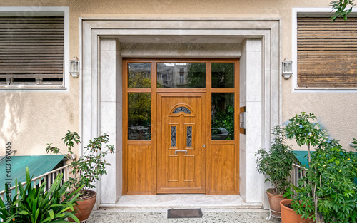 contemporary classic design apartment building front entrance wooden door and potted plants