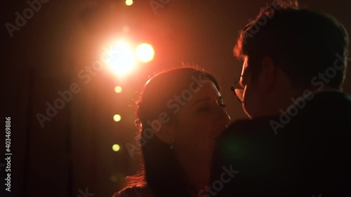 Newly wed couple dance together at their evening party in the golden lights in the dark