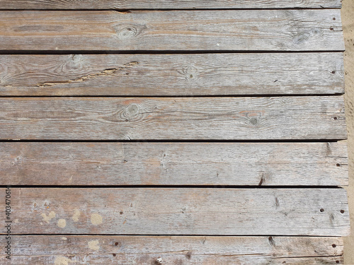 Board Wooden texture background with cracks on sandy beach. Top view, closeup