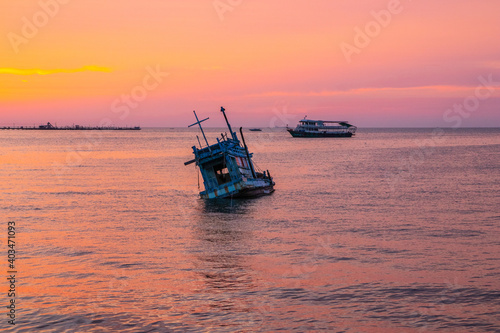 an old ship during the sunset on the sea in the Gulf of Thailand