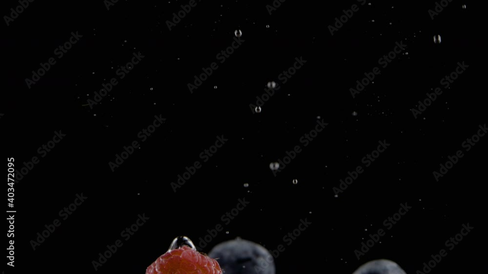 Raspberries, blueberries and blackberries falling into water in slow motion. UHD. 120FPS Raspberries, blueberries and blackberries falling into water in slow motion. UHD. 120FPS