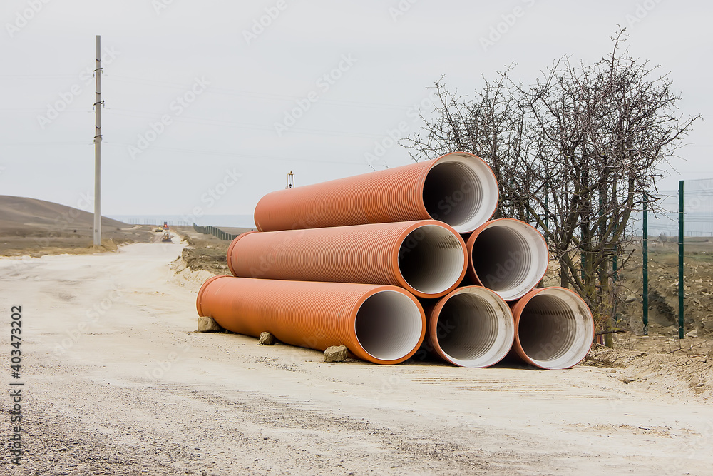 Large diameter water pipes are located at the edge of the road. Large diameter water pipes are located at the edge of the road.