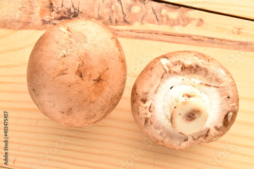 Two organic fresh, cream champignons, close up, on a wooden table.