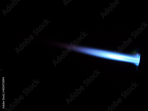 The glow of a gas lighter torch in the dark.