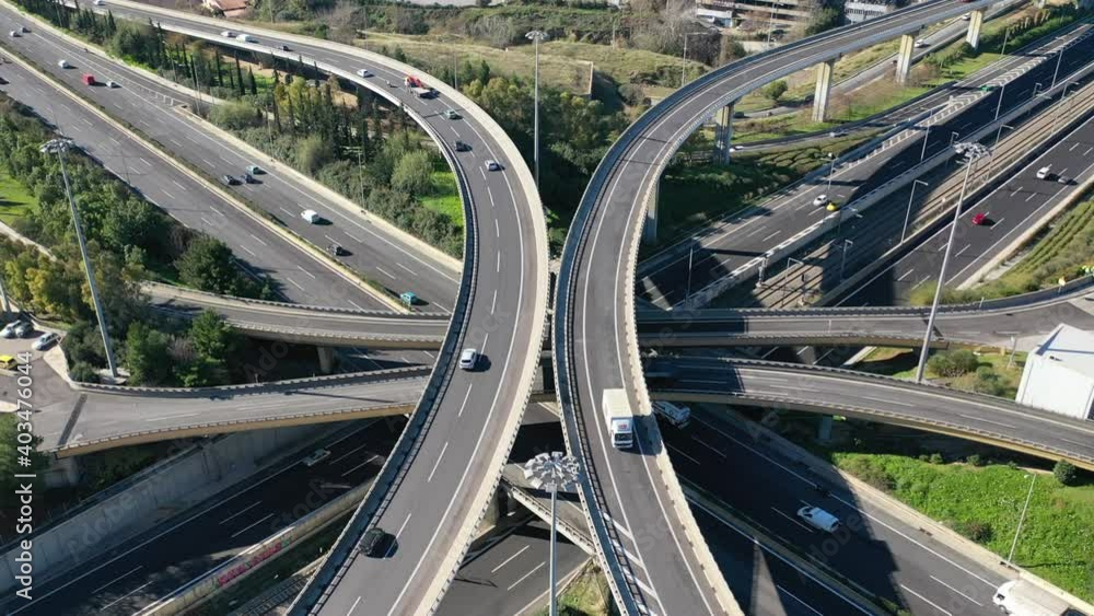 Aerial drone top down time-lapse video of motorway multilevel junction crossing through national road during rush hour, Attica, Athens, Greece. Aerial drone top down time-lapse video of motorway multilevel junction crossing through national road during rush hour, Attica, Athens, Greece.