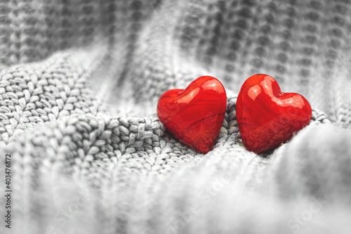 Valentine s Day two red hearts background  couple  greeting card and concept of love  blurred  copy space banner  knitted sweater