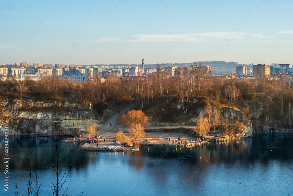 Fototapeta premium zakrzowek lake, lagoon, quarry at fall, autumn golden hour. Landscape of lake, forest and city in the background. Cracow, ruczaj. 