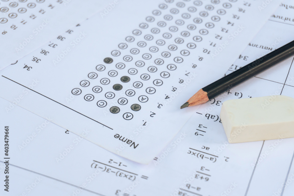 Pencil and eraser on answer sheets or Standardized test form with answers bubbled. multiple choice answer sheet Pencil and eraser on answer sheets or Standardized test form with answers bubbled. multiple choice answer sheet