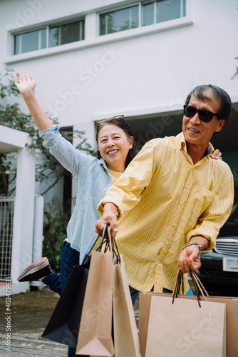 Cheerful senior couple with shopping bags.