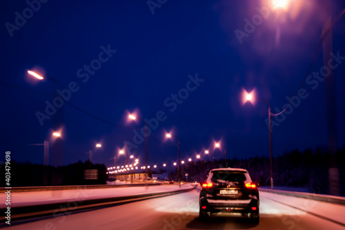 Night highway in winter. Light headlights in the dark, the movement of cars from the viewer