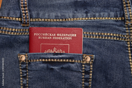 Red international passport of Russia in the pocket of blue jeans. Travel concept.