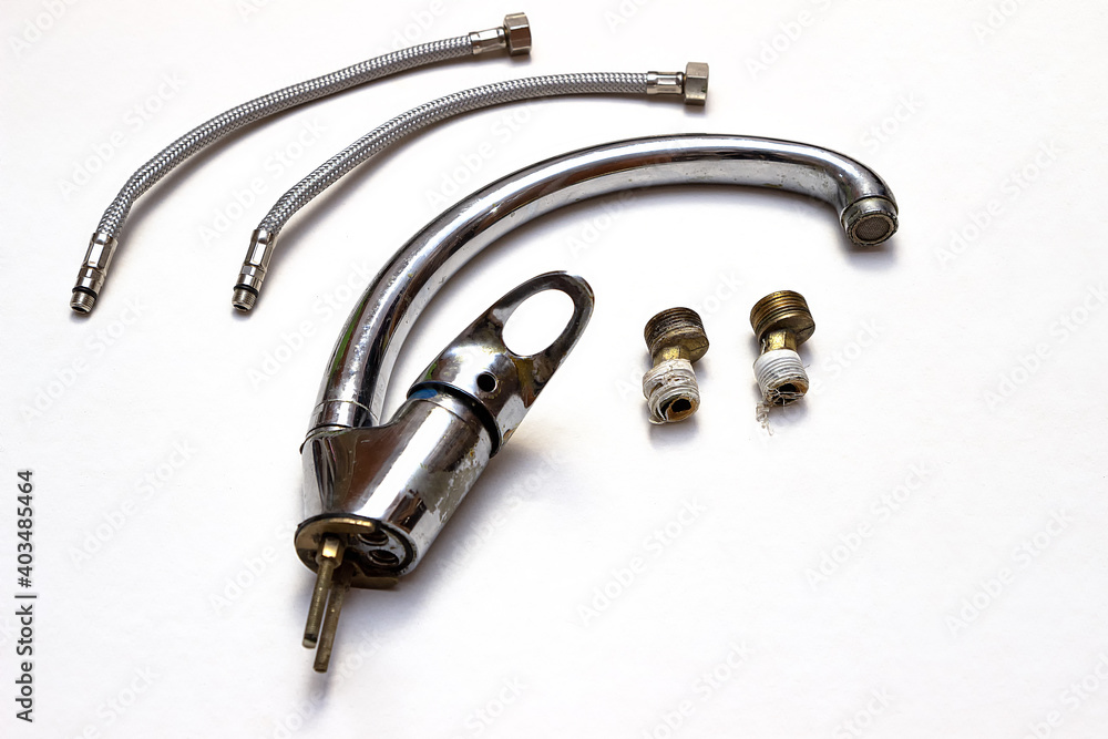 Closeup of Kitchen Used Water Faucet with water hoses and plumbing adapter. Isolated Over White Background. Horizontal Image Composition Closeup of Kitchen Used Water Faucet with water hoses and plumbing adapter. Isolated Over White Background. Horizontal Image Composition