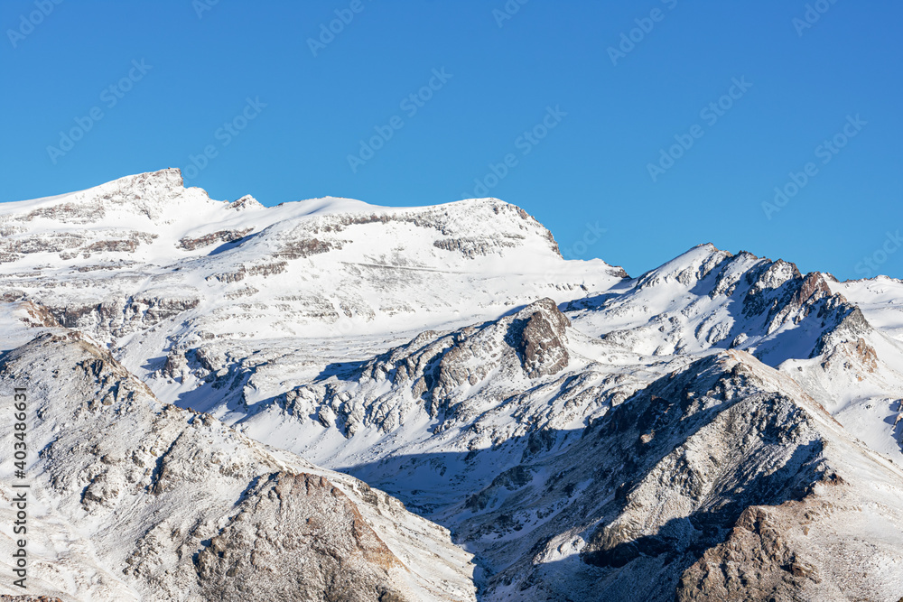 Summits of Sierra Nevada in winter and with snow, landscape of the peaks and edges of the mountain range with the Veleta as the main peak.