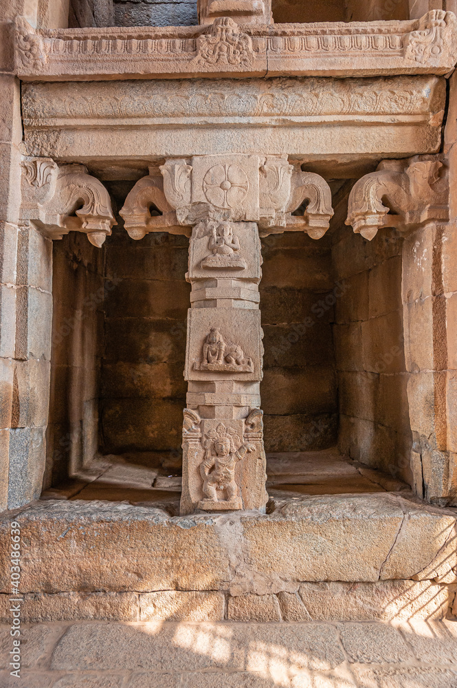 Hampi, Karnataka, India - November 5, 2013: Sri Krishna temple in ruins. Brown stone empty entrance office niche with sculpted frame and pillars. Some damaged frescos. Hampi, Karnataka, India - November 5, 2013: Sri Krishna temple in ruins. Brown stone empty entrance office niche with sculpted frame and pillars. Some damaged frescos.