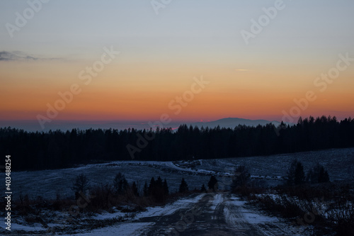 Colorful sunset in cold winter forest © Matej