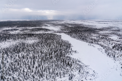 The arctic ocean, boreal forest in northern Canada, Churchill Manitoba seen in November, fall, autumn season with ice, icy shards and patches of tundra land. 