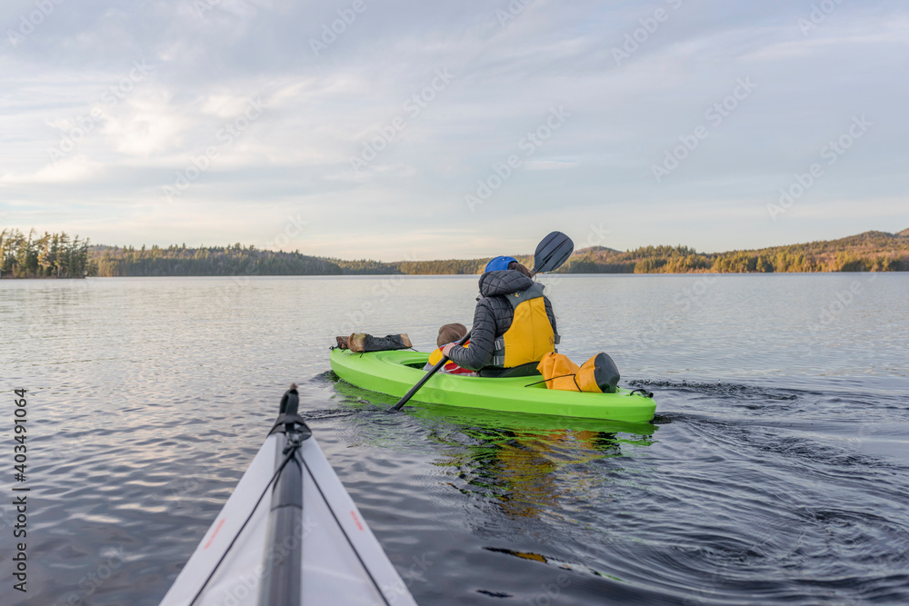 Obraz premium A mother and baby kayaking in open water in an Adirondack watershed
