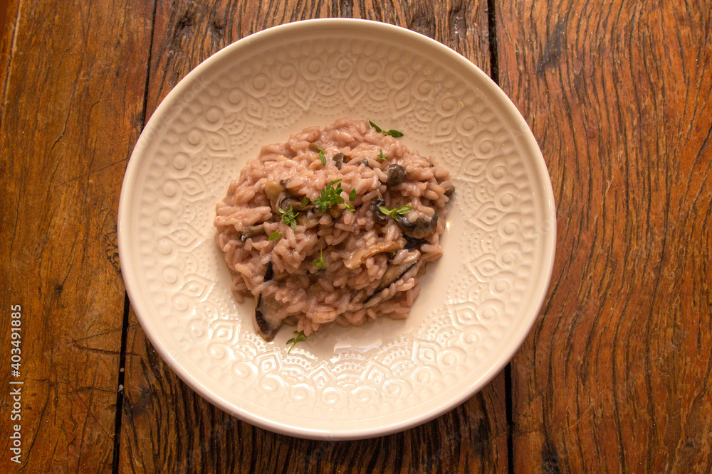 Mushroom risotto, on the wooden table.