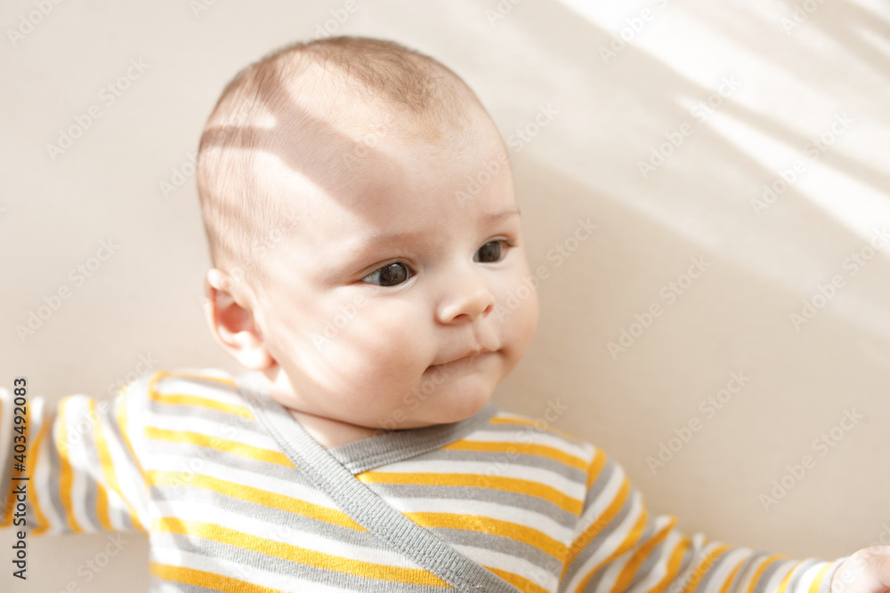 Adorable baby in a white sunny bedroom. Newborn baby is resting in bed. Family morning at home. Adorable baby in a white sunny bedroom. Newborn baby is resting in bed. Family morning at home.