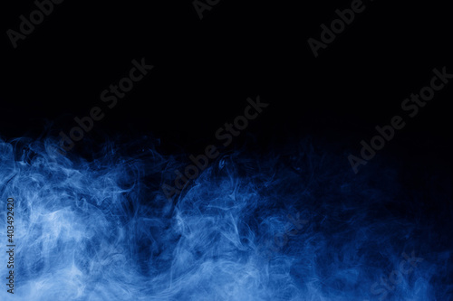 Abstract blue smoke moves on black background. Swirling smoke.