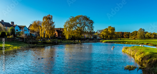Fotografie The River Stour winds past houses on the edge of Sudbury, Suffolk on a sunny aut