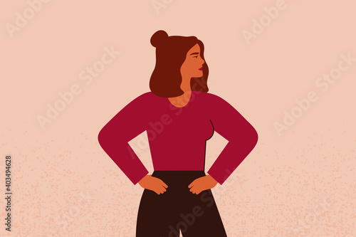 Young strong female with hands on her hips looks forward. Confident Businesswoman or entrepreneur in corporate clothing. The concept of gender equality and of the female empowerment movement.