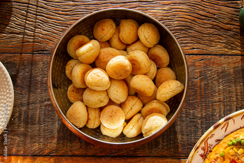 Brazilian cheese bread in a pan on wooden table. Brazilian cheese bread in a pan on wooden table.