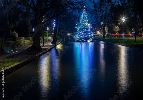 Illuminated Christmas tree in the river at Bourton-on-the-Water in the Cotswolds. © Peter Greenway