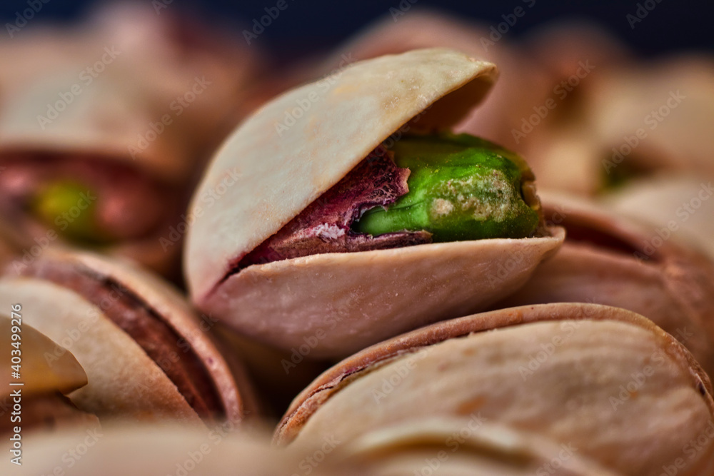 Close-up of green pistachio with open shell, next to more pistachios Close-up of green pistachio with open shell, next to more pistachios