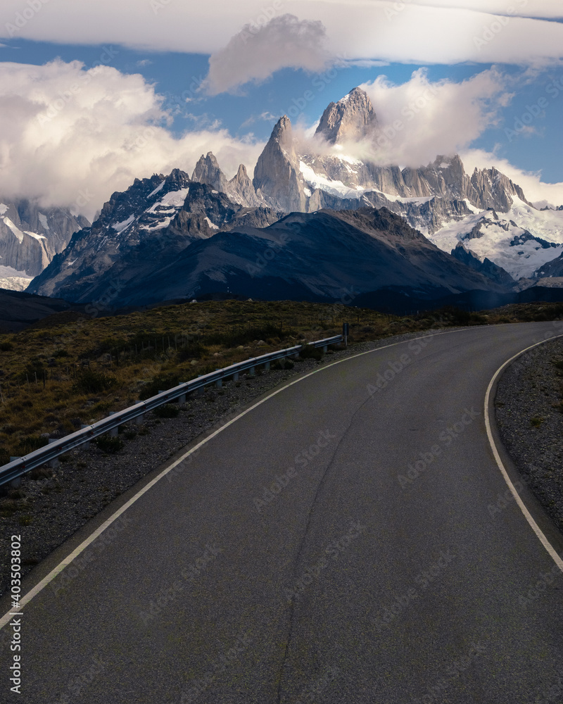 Asphalted road with the peaks of a rocky and snowy mountain on the horizon. Fitz Roy mountain in Argentina vertical Photograph