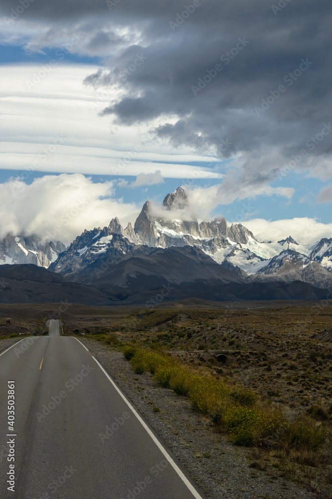 Asphalted road with the peaks of a rocky and snowy mountain on the horizon. Fitz Roy mountain in Argentina vertical Photograph