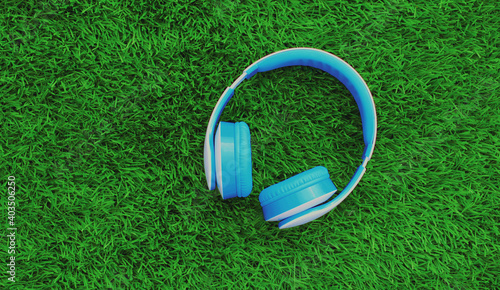 Close up blue wireless headphones on a green background, top view