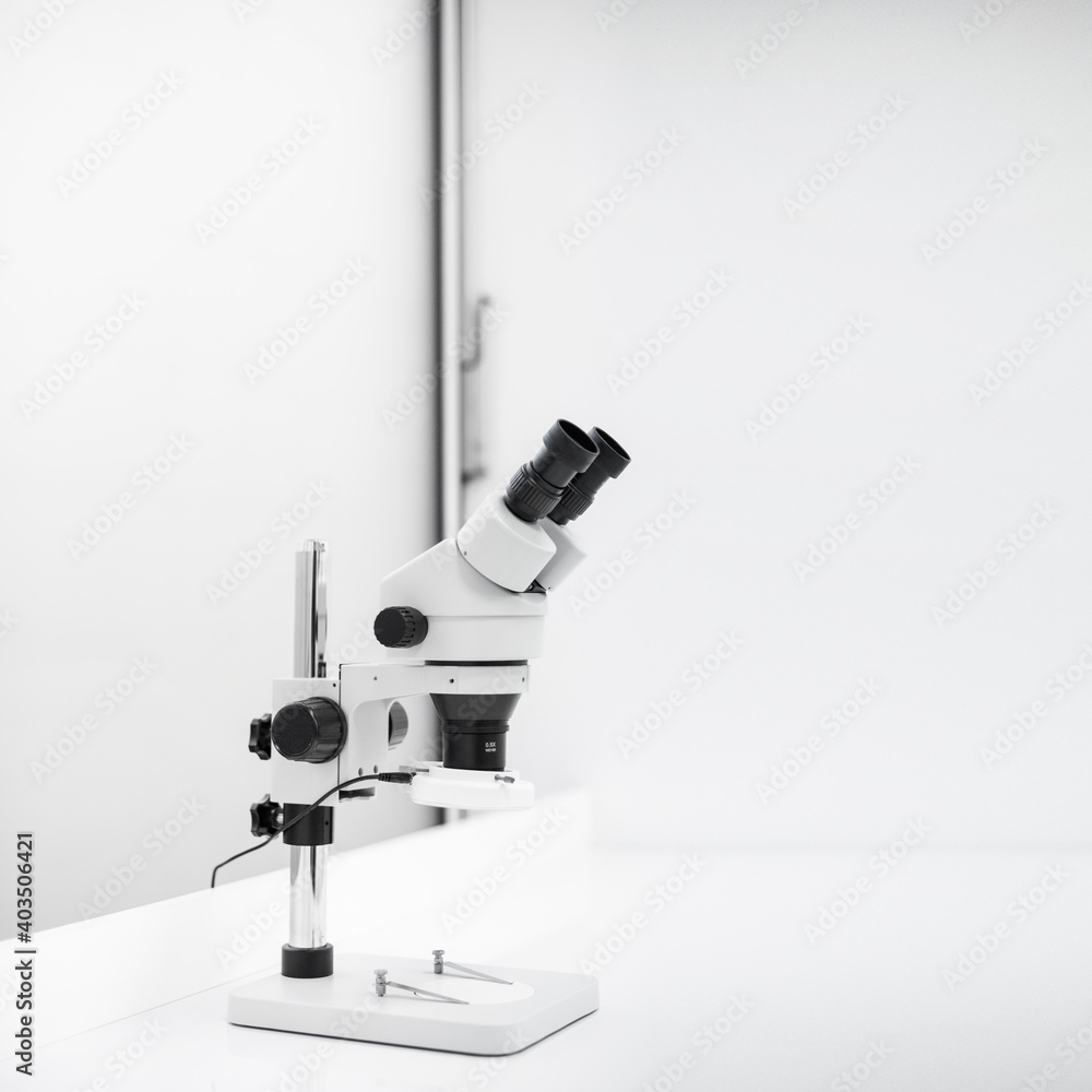 Nowoczesny biały mikroskop stojący na biurku w sterylnym laboratorium - obrazy, fototapety, plakaty 