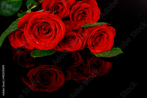 Bouquet of beautiful red roses isolated on black background with reflection.