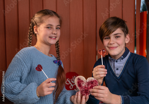 Obraz na płótnie boy and a girl, with helium balloon give shape of a heart sweet candies, laugh. w salonie